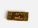 a gold bar on a white surface with a white background