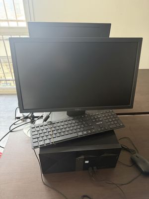 un écran d'ordinateur et un clavier posés sur un bureau, avec une souris et un clavier