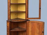 an old wooden corner cabinet with a mirror on top of it