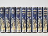 six books in a row with a blue cover and gold foil on them