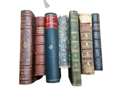 several old books are lined up in a row on a white surface