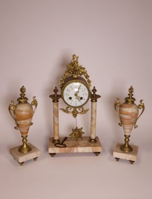 a clock and two vases sitting on a table