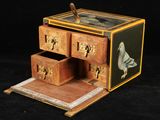 une petite boîte en bois avec des tiroirs et un oiseau dessiné dessus
