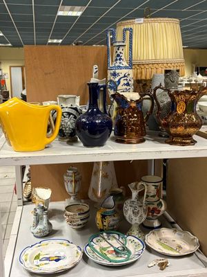 de nombreux vases et assiettes posés sur une étagère dans une pièce