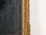 a mirror with a gold frame on the wall