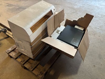 a laptop sitting inside of a box on a pallet