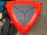 a red triangle shaped object on the ground next to a pair of gloves and a pair of gloves