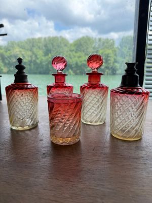 four bottles of perfume sitting on a table next to a window