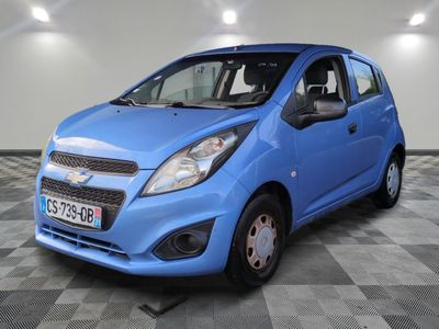 la petite voiture bleue est garée sur un sol en damier