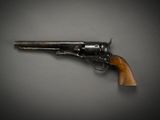 an old revolver with a wooden handle on a gray background