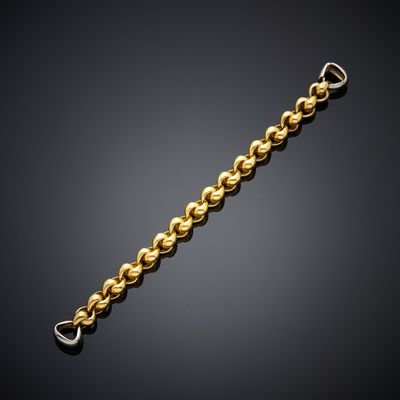 a gold chain bracelet with a clasp on a black background