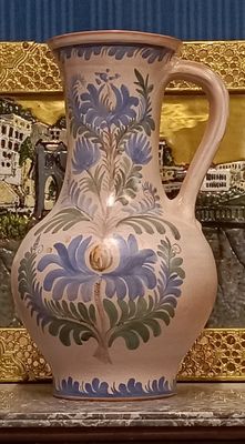 a vase that is sitting on a table in front of a picture