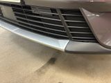 the front end of a car with a denting dent on it ' s bumper