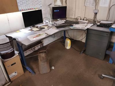 un bureau sur lequel sont posés deux écrans et un ordinateur portable