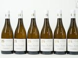 six bouteilles de vin sont alignées sur une surface blanche
