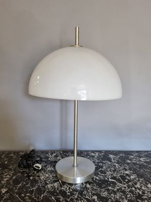une lampe de table blanche posée sur un plan de travail en marbre