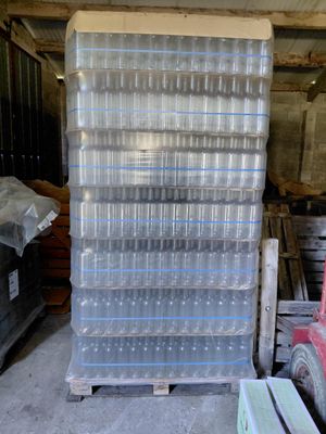 une pile de bacs en plastique posée sur une palette dans un entrepôt