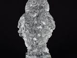 figurine de chouette en cristal posée sur un socle transparent, sur fond noir
