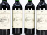 three bottles of red wine are lined up on a white surface