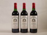 trois bouteilles de vin rouge posées côte à côte sur une table