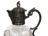 a glass pitcher with a metal handle on a white background