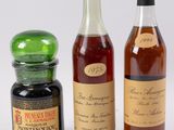 trois bouteilles de vin et une bouteille de miel sont posées les unes à côté des autres