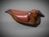 wooden bird figurine sitting on top of a gray surface