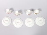 six porcelain cups and saucers with flowers on them on a white surface