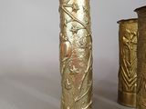 two gold vases sitting next to each other on a table