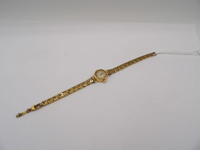 a close up of a gold watch on a white surface