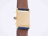 a close up of a watch on a white surface with a brown strap