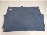 a close up of a blue sweater on a white table