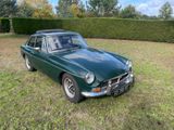 une photo d'une voiture verte garée dans l'herbe