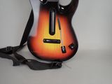 a guitar that is sitting on a table with a strap around it