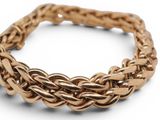 a close up of a gold bracelet on a white background