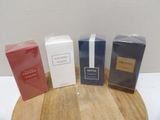 three boxes of perfume sitting on top of a wooden table