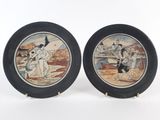 pair of decorative plates depicting a man and a woman on a beach