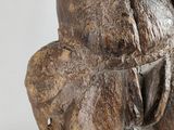 a wooden statue of a man holding a baby elephant