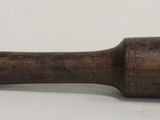 a close up of a wooden mallet on a white surface
