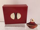 une boîte rouge avec un flacon de parfum à côté