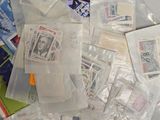 a pile of stamps on top of a table next to a pair of scissors and a pair of scissors