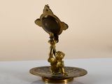 a gold plate with a small statue on top of it