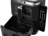 an image of a black and silver air fryer with a remote control