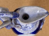 a blue and white vase that has a fish on it