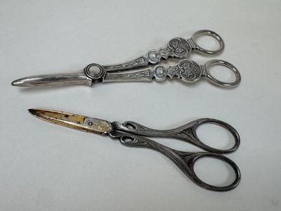 two pairs of scissors sitting on a white surface