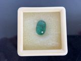 a close up of a green stone in a white box