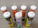 six tubes de colle sont alignés en rang sur une table