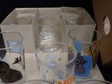 many glasses and cups sitting on a table next to each other