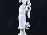 une image représentant une statue d'une femme avec un oiseau sur l'épaule