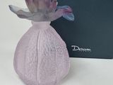 purple glass vase with a purple flower in front of a black box